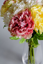 An arrangement of faux mixed peonies. 