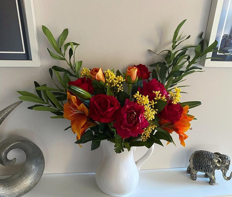 Styling artificial flowers in a vase.